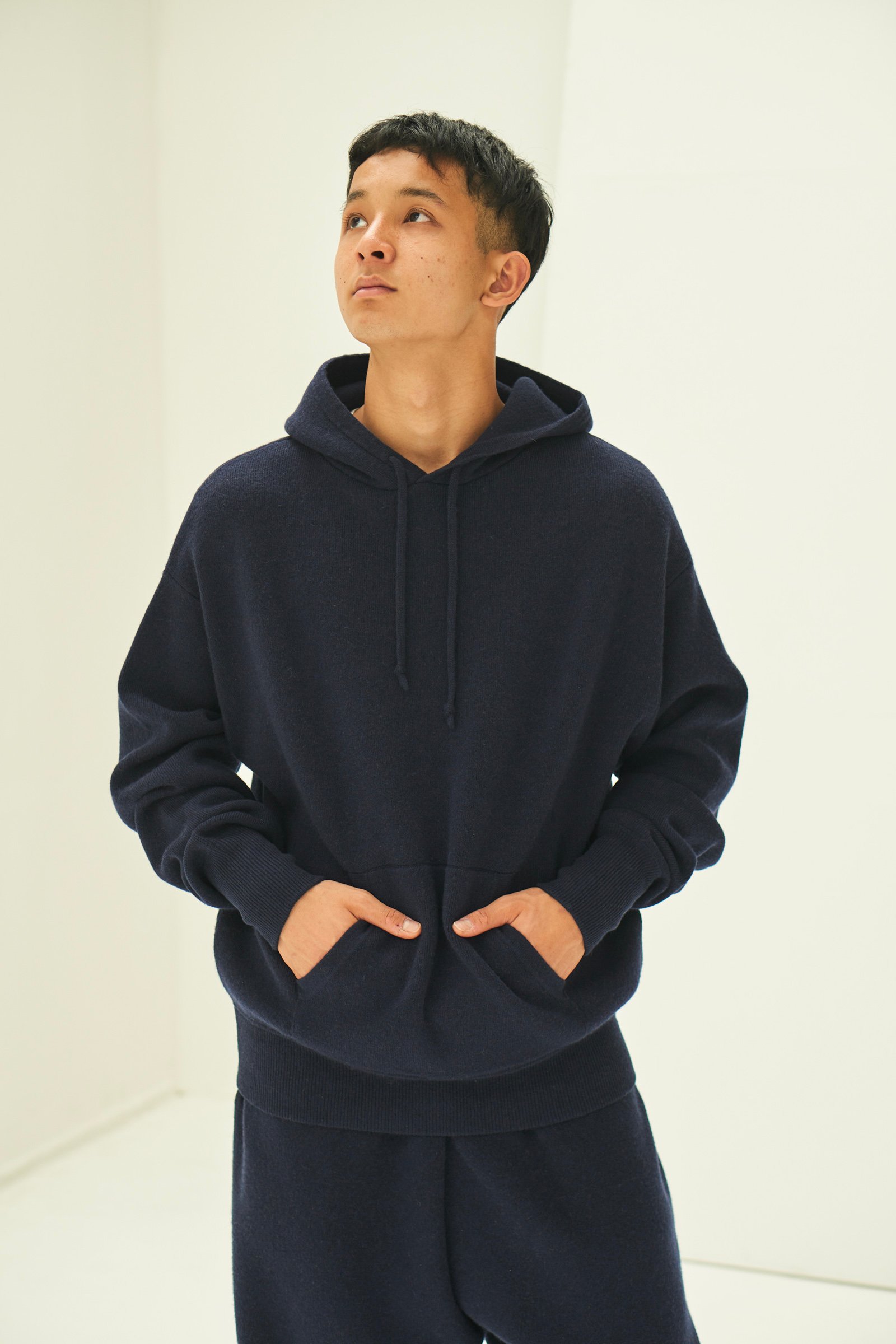 ブラックのニットフーディーを着用した男性モデル