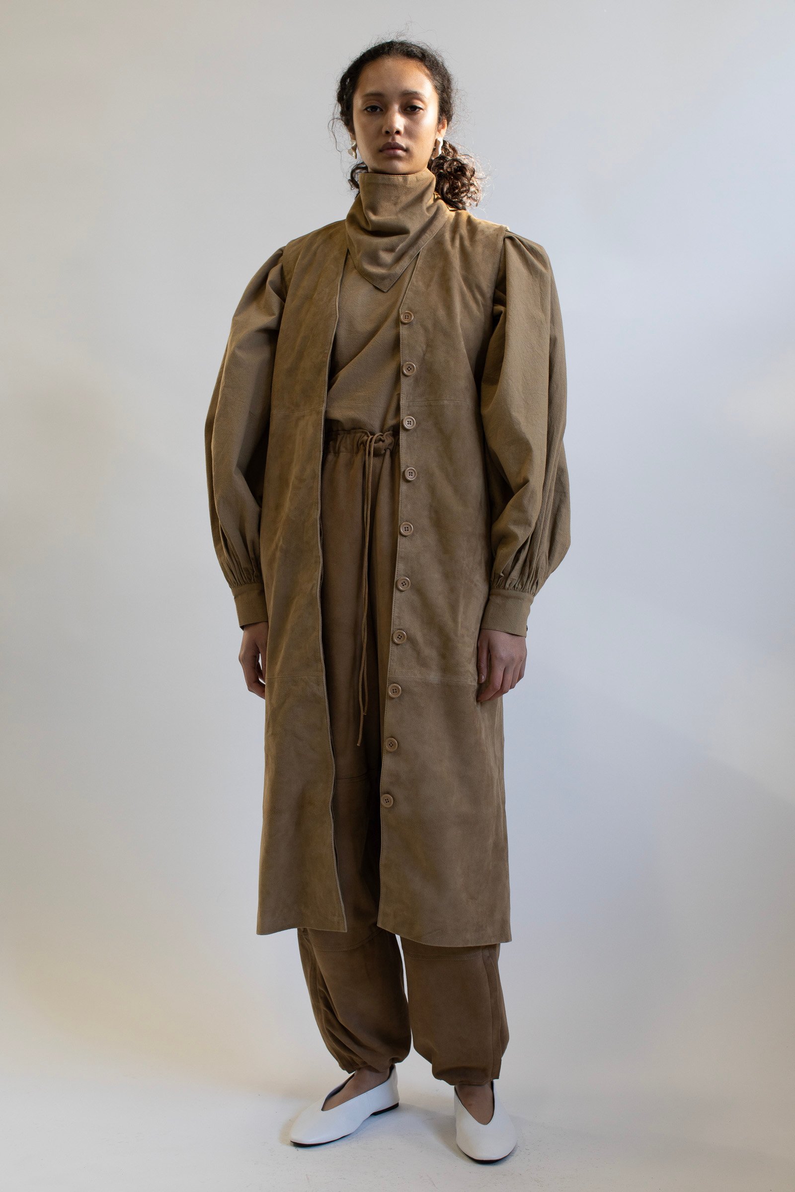 レザーのロングベストを着用した女性モデル