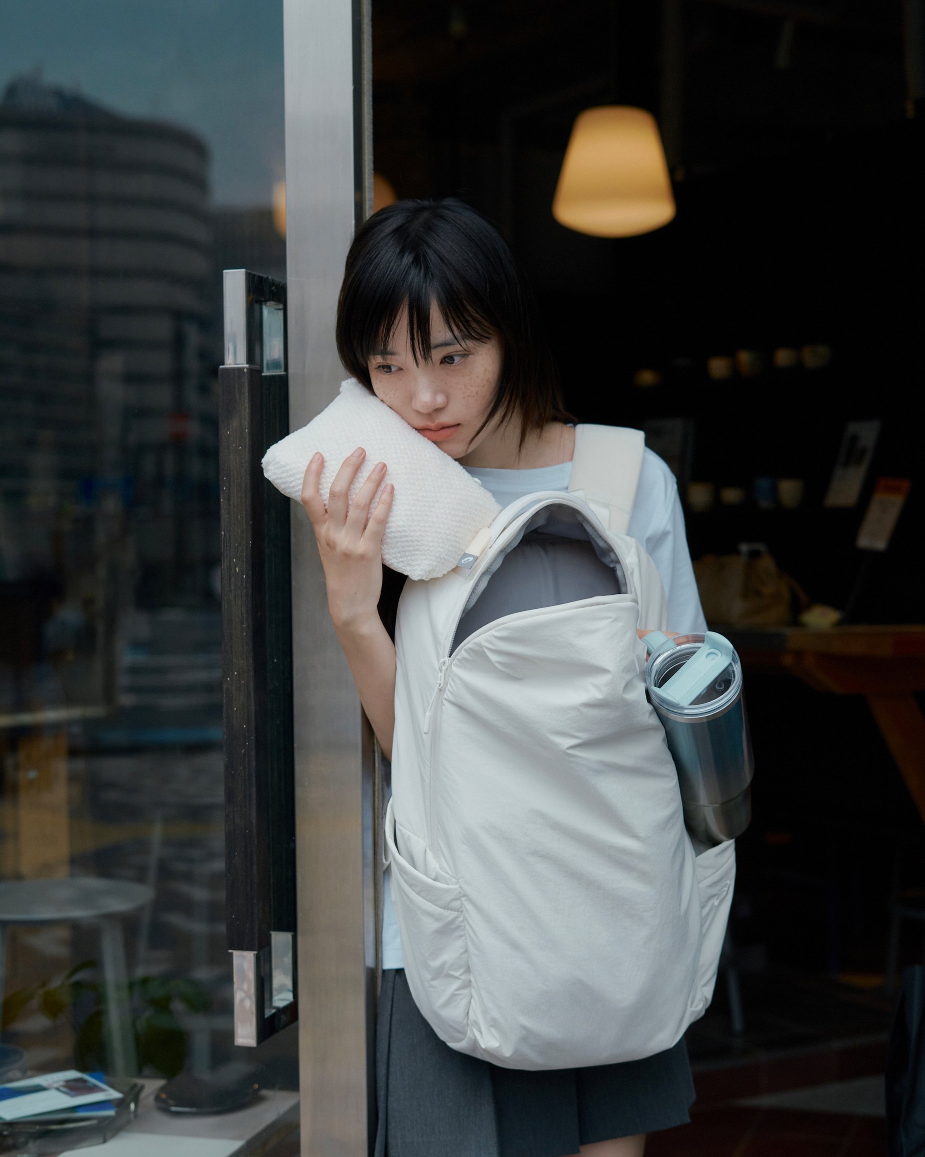 アシックスのバックパックを持った女性