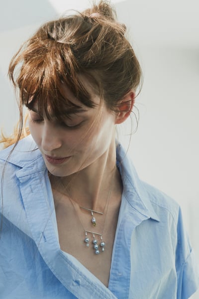 ブルーのパールのネックレスを着用した女性