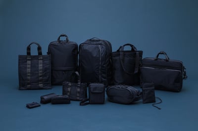 青の床と壁に置かれた複数のネイビーのバッグ