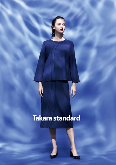 ネイビーのジャケットとスカートを着用した女性