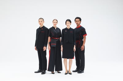 赤がアクセントの黒い制服を来た4名の男女の画像