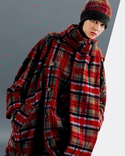 赤いタータンチェックのブラウスと帽子を着用した女性