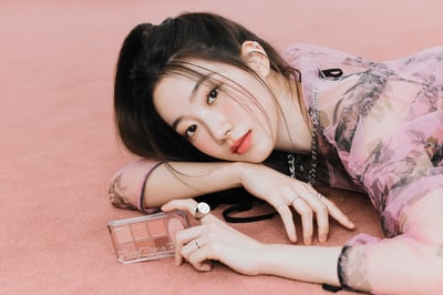 アイシャドウを手に持ち横たわる女性