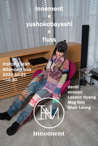 カラフルなニットとデニム、グレーのニット帽を着用した女性