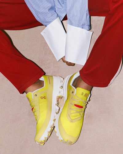 黄色いスニーカーと赤いパンツを着用した足元