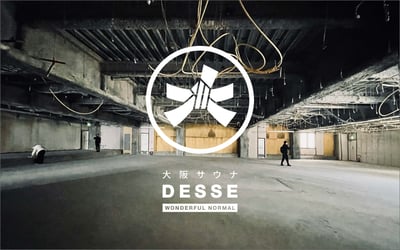 コンクリートの建物内観と大阪サウナ DESSEのロゴ