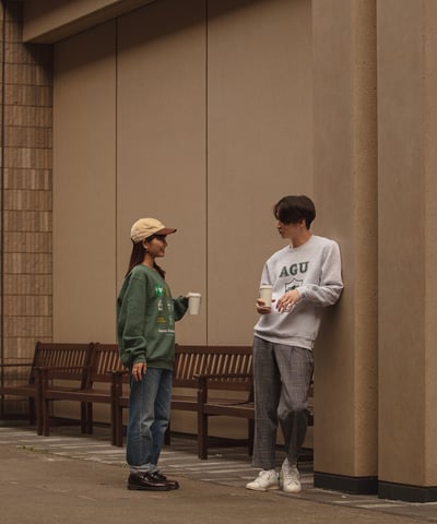 グレーのスウェットとグリーンのスウェットを着用した男女