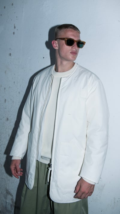 白いコートを着用した男性