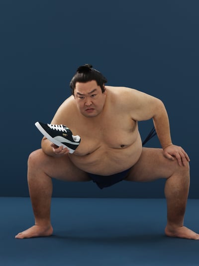 黒いスニーカーを手に持った力士