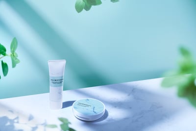 白いチューブに入った日焼け止めとグリーンの容器に入ったフェイスパウダー