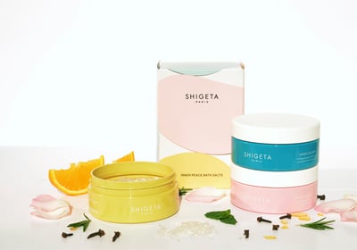 花や果実とともにカラフルな円柱状のパッケージが積み重なっている様子