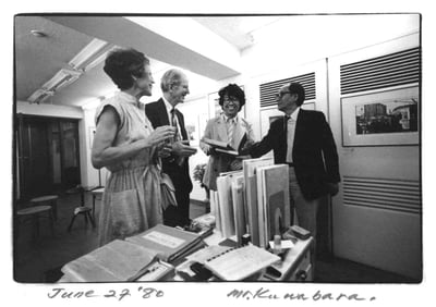 ４人の男女が談笑するモノクロ写真