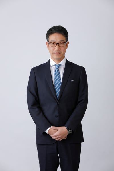 前で手を組む男性