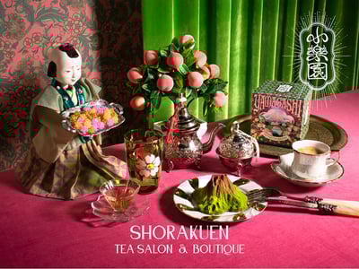 山の形を模した和菓子や紅茶をセットしたピンクのテーブルと小楽園のロゴ