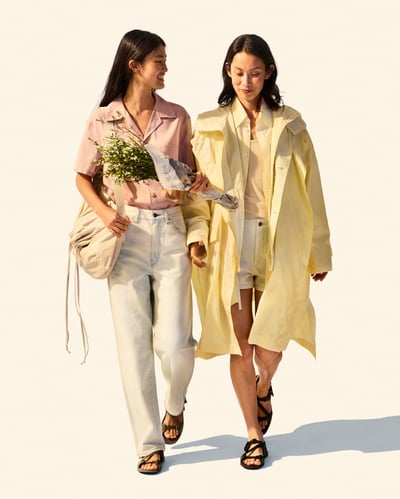 イエローのコートを着用した女性と白いジーンズとピンクのシャツを着用した女性