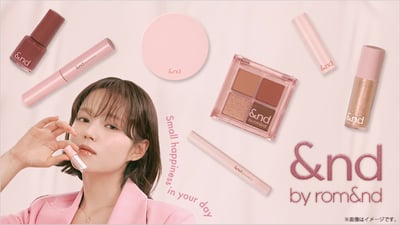 ブランドイメージ画像 メイクアイテムとピンクスーツを着た女性が左に映る