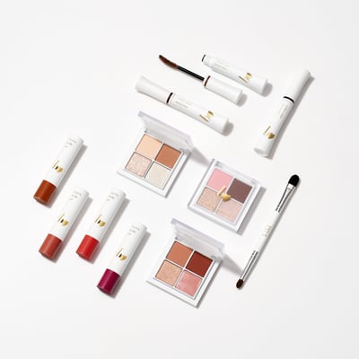 白い背景の上に並べられたアイパレットなど数々の化粧品