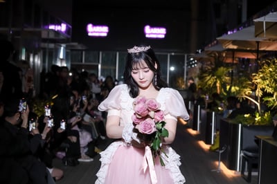 花束を持ってランウェイを歩くモデル