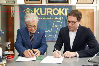 サインをするクロキ株式会社 代表取締役社長 黒木立志氏とLVMH メティエ ダール CEO マッテオ・デ・ローサ氏