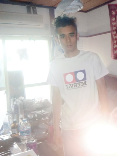 ファッションブランド「LVSYM」のロゴ入りTシャツを着用した男性