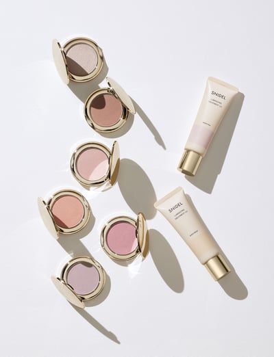 ゴールドの容器に入ったチークとクリームカラーの容器に入った化粧下地