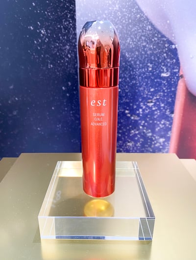 クリアな台に乗ったオレンジ色のボトルの美容液