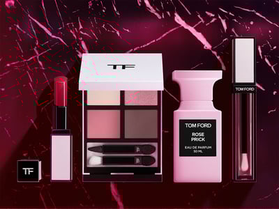 ピンクの背景にローズ系の複数のコスメが配置されている