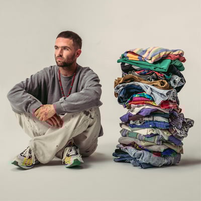 積み上がった洋服と男性