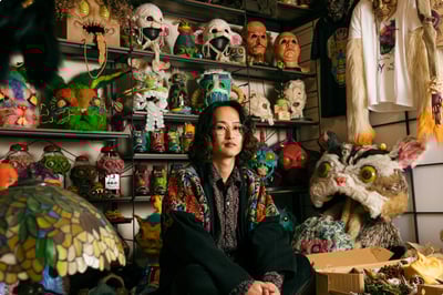 作品を背景に座る快歩