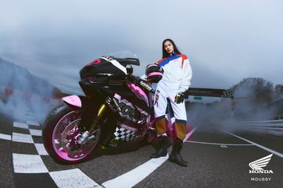 ピンクのバイクとヘルメットを持った女性