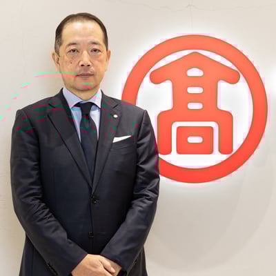 ロゴの前に立つ男性