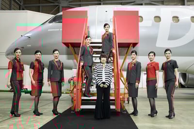 新制服を着用した客室乗務員とコシノジュンコ本人の集合写真