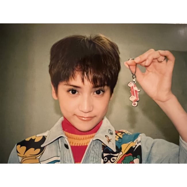 ショートカットの女性が左手にキーホルダーを持つ写真