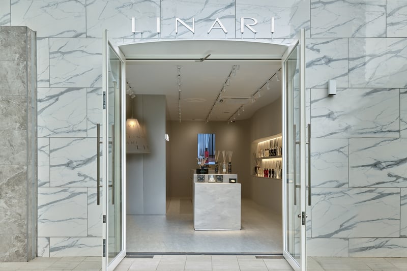 大理石デザインの壁で作られ、大きな扉が開いている店舗の外観