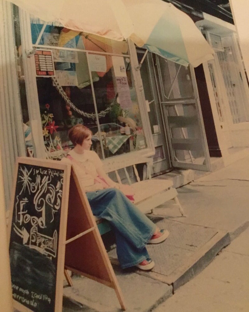 お店の前に女性が座っている写真