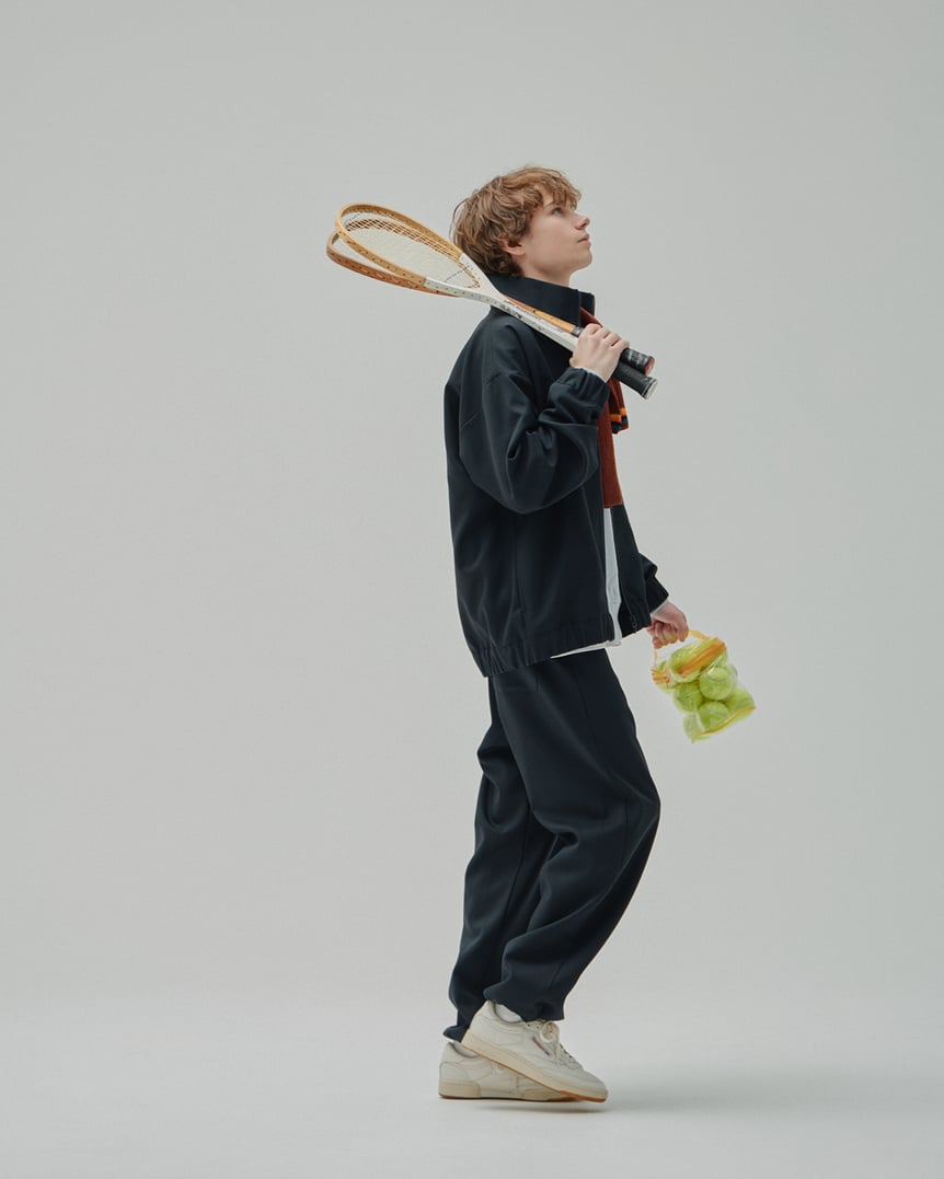 ネイビーのトラックジャケットとパンツを着た白人男性モデル