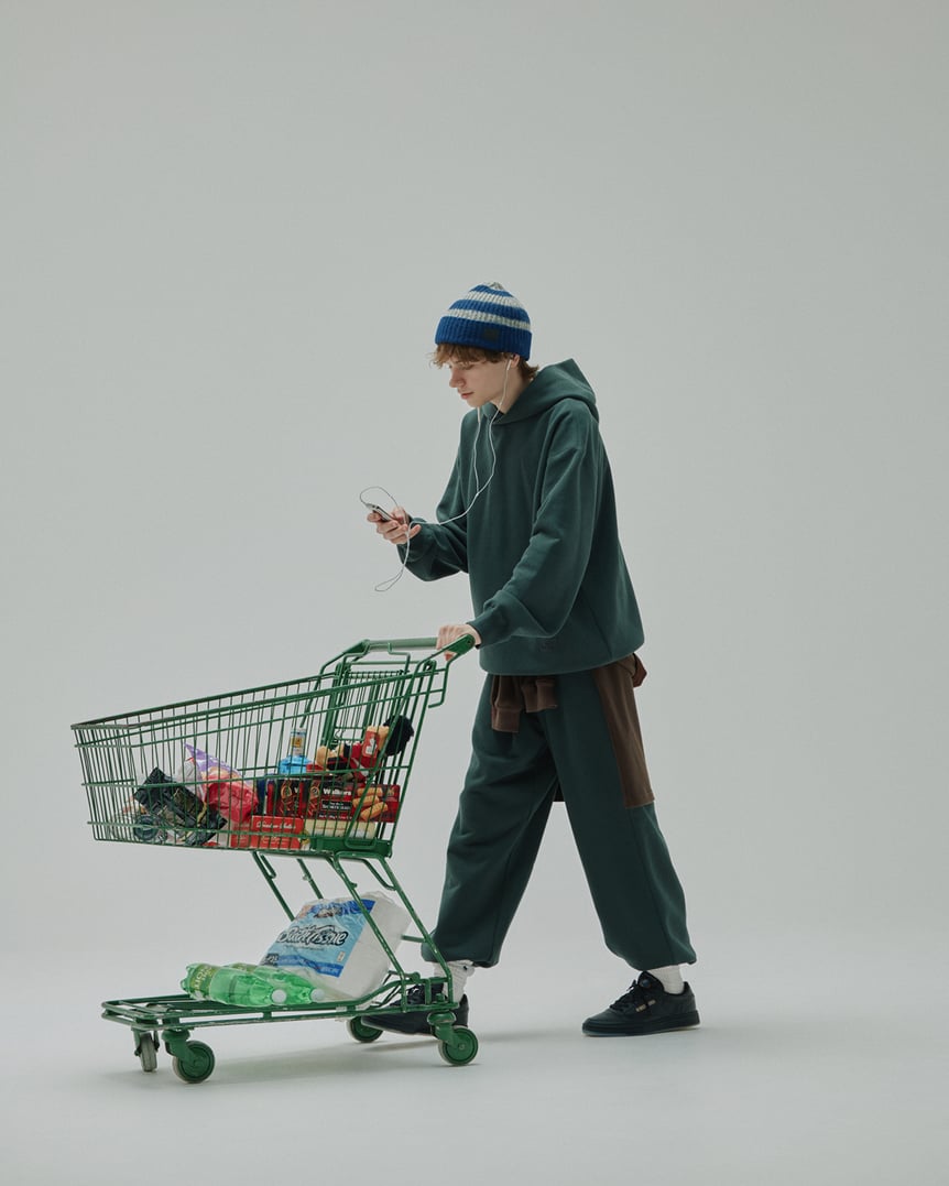 グリーンのスウェットセットアップを着た白人男性モデル