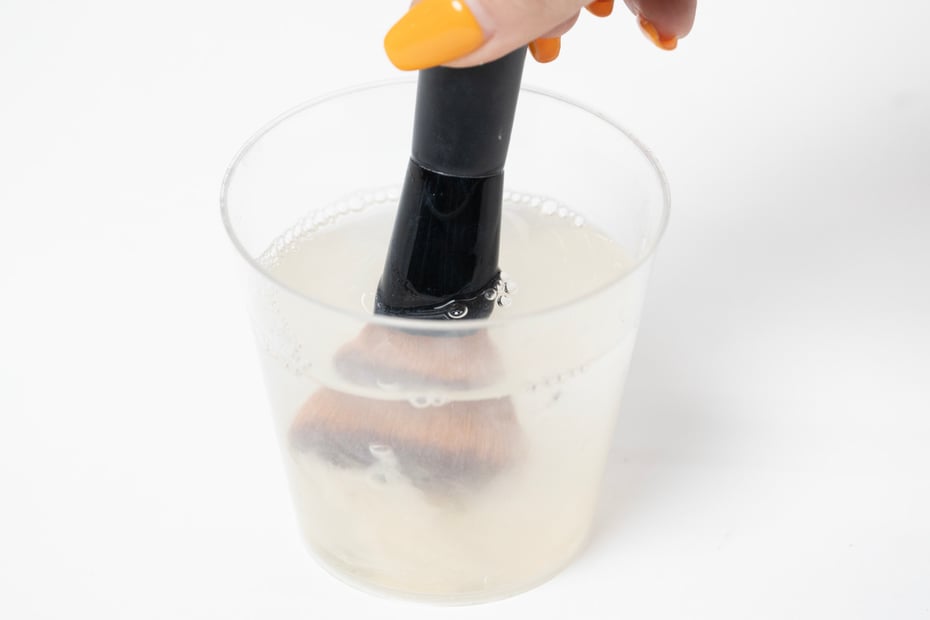 ②ブラシの根元から筆先をぬるま湯に浸け、軽く振り洗いをした後、毛先を軽く押さえるように洗う。 Image by FASHIONSNAP